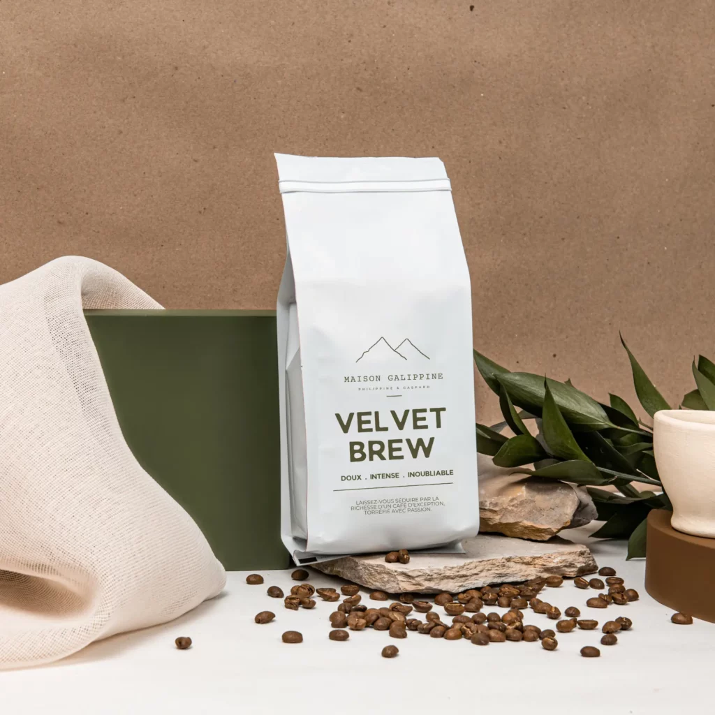 sachet de café maison gallipine, mis en scène dans un décor floral avec grains de café sur la table